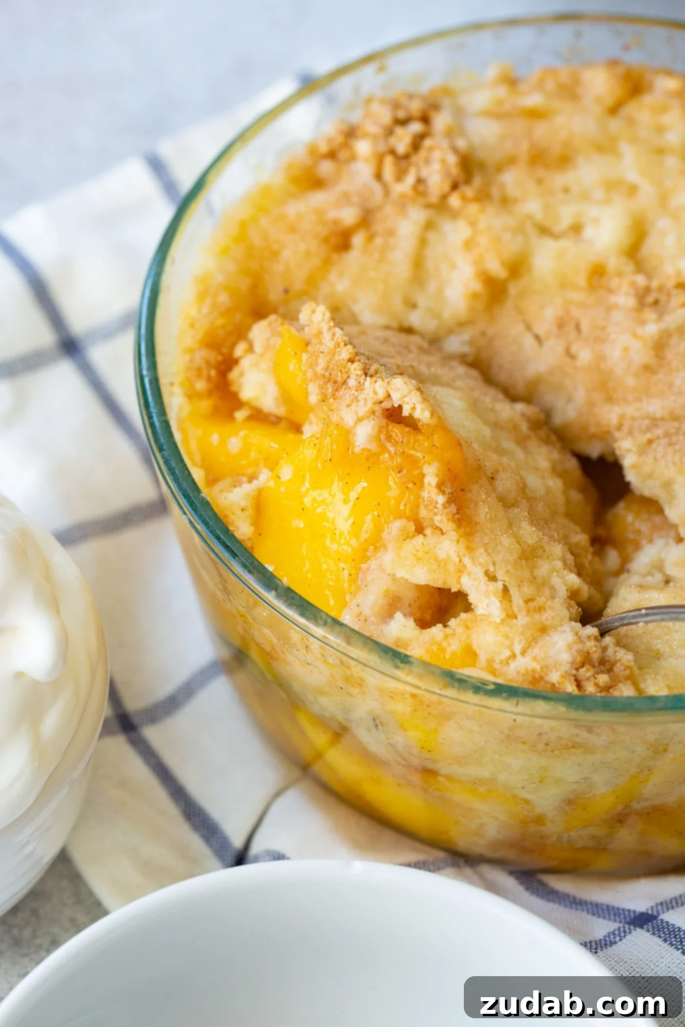 Easy Instant Pot Peach Cobbler with Cake Mix A freshly cooked Instant Pot Peach Cobbler, bubbling with sweet peaches and a golden brown cake mix topping.