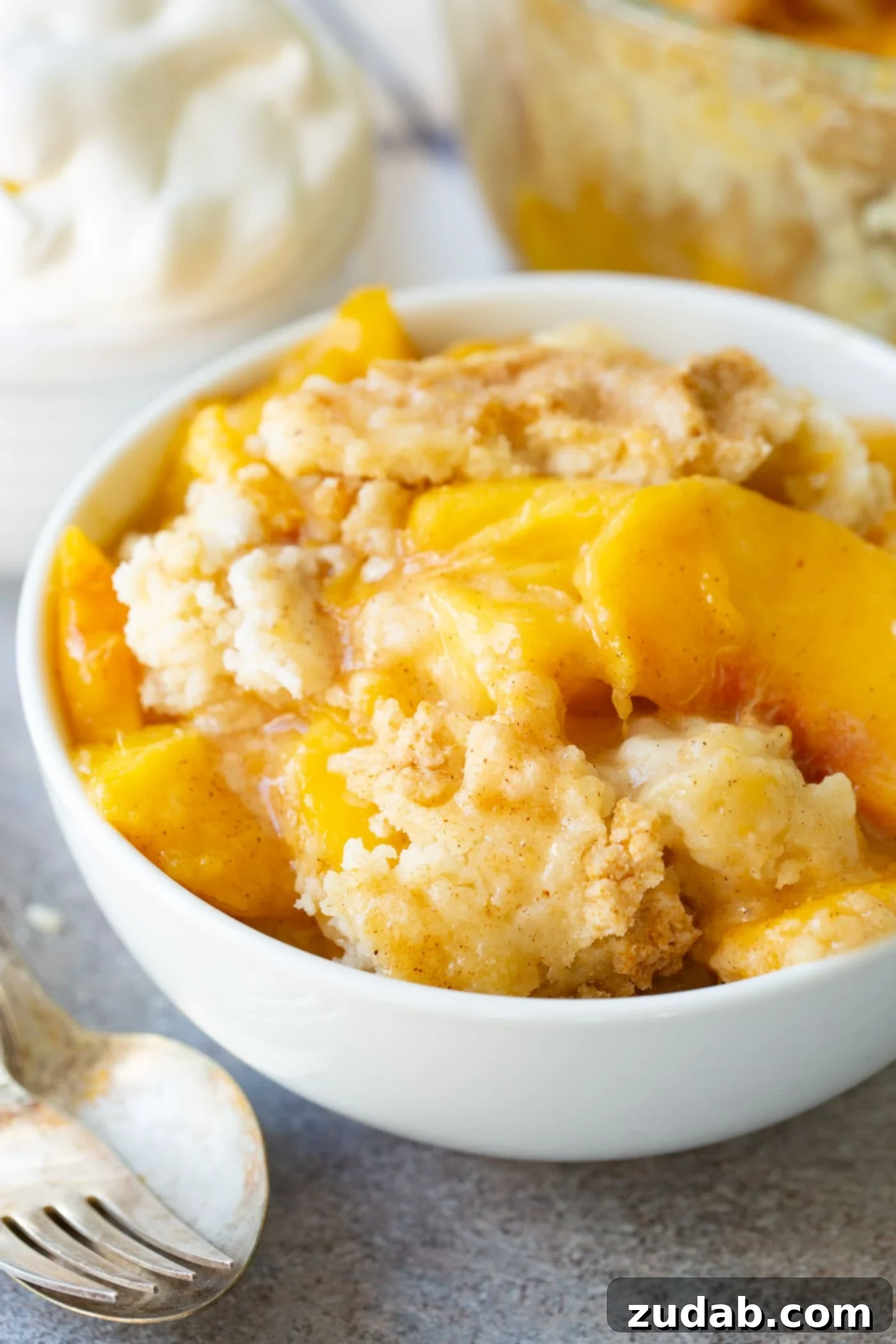 Easy Instant Pot Peach Cobbler with Cake Mix Three individual servings of Instant Pot Peach Cobbler, each topped with a delicate cake mix crust.