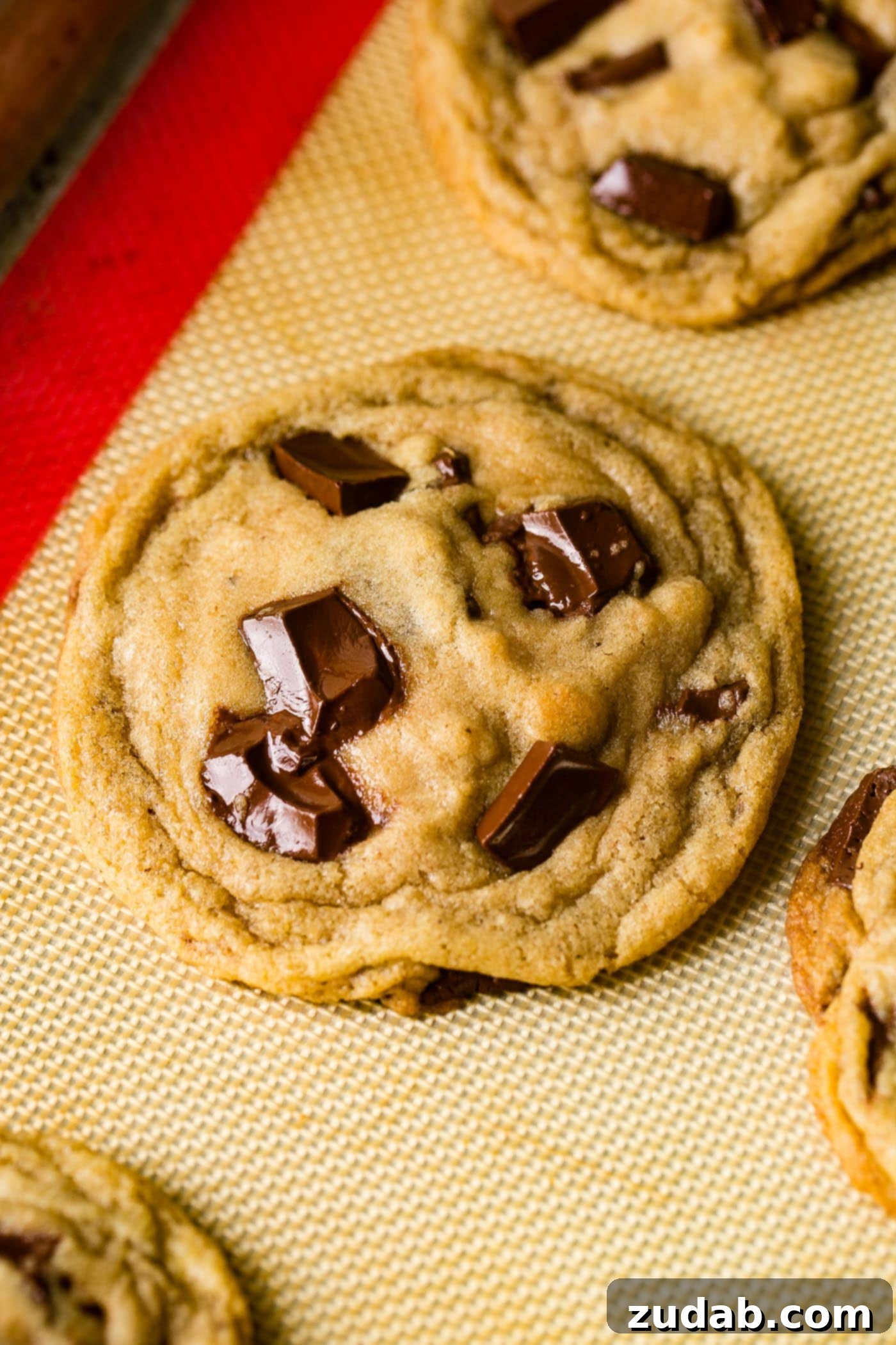 Chocolate Lover's Ultimate Chocolate Chip Cookies 4 A close-up of a warm, irresistible chocolate chip cookie, boasting melted chocolate pockets and sparkling sea salt crystals.