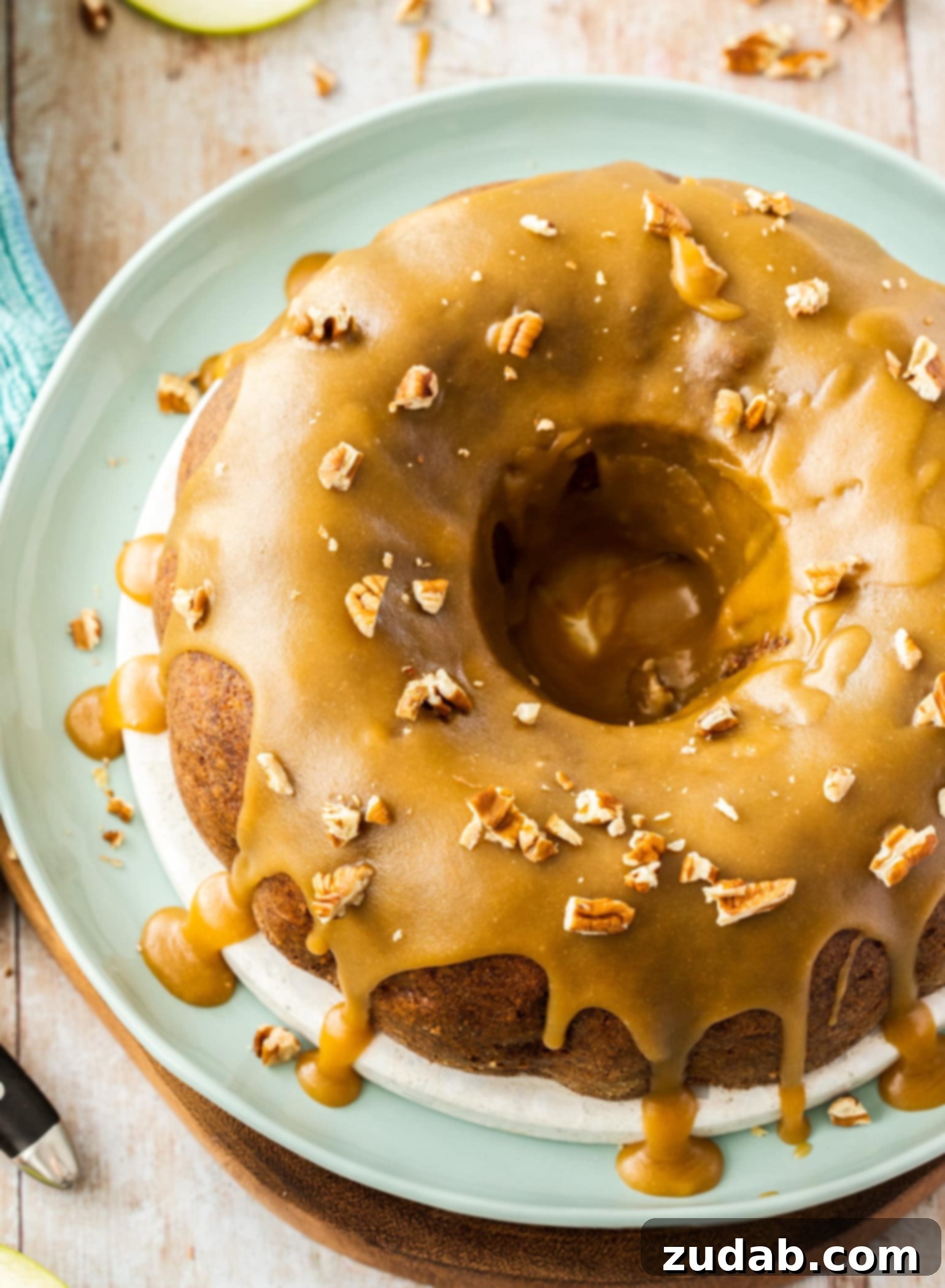 Spiced Apple Pecan Bundt 4 Birdseye view of an apple cinnamon bundt cake with caramel icing drizzling down the sides