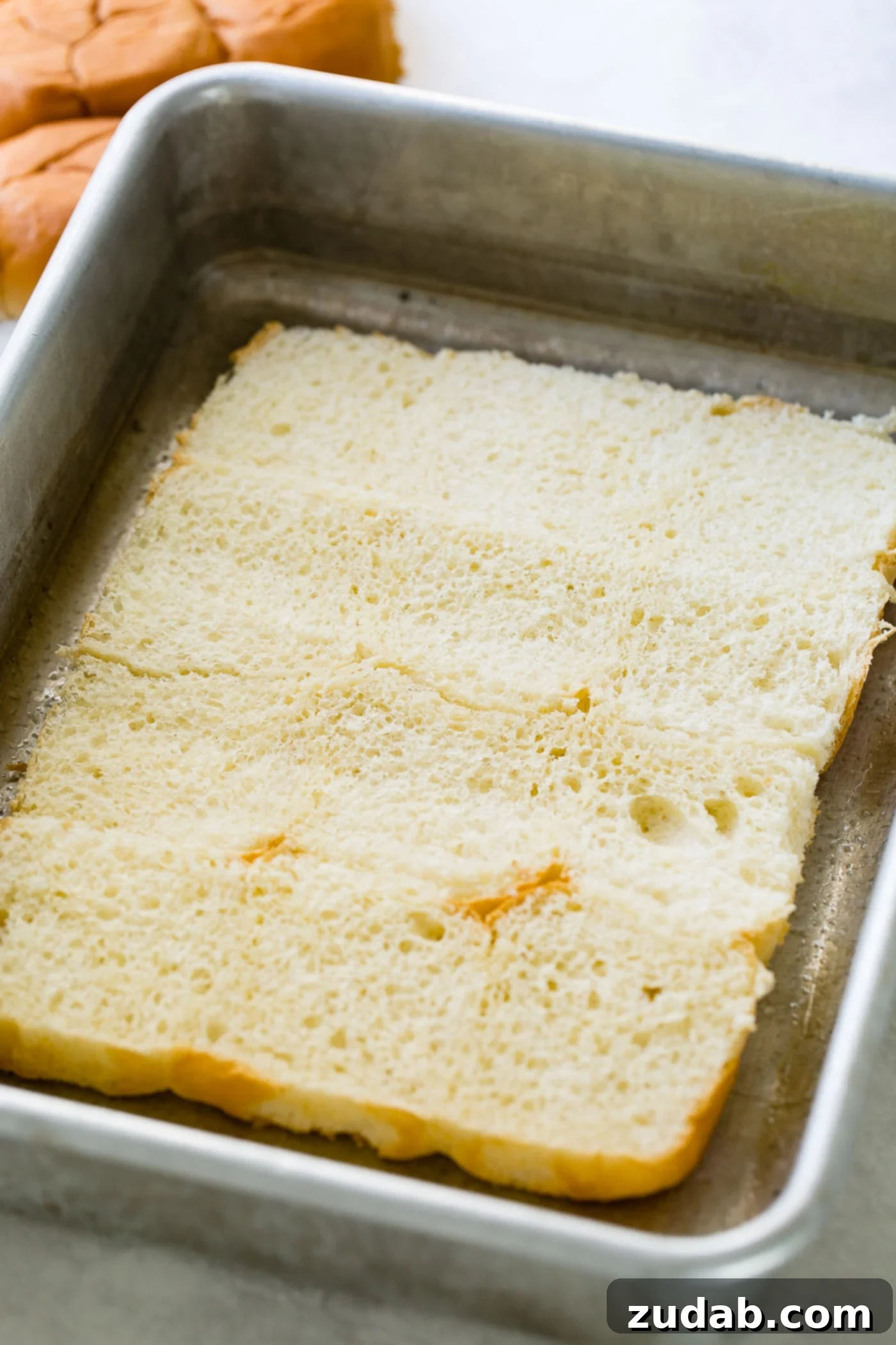 French Dip Sliders A photo of a layer or slider rolls sliced in half and laying in a pan.