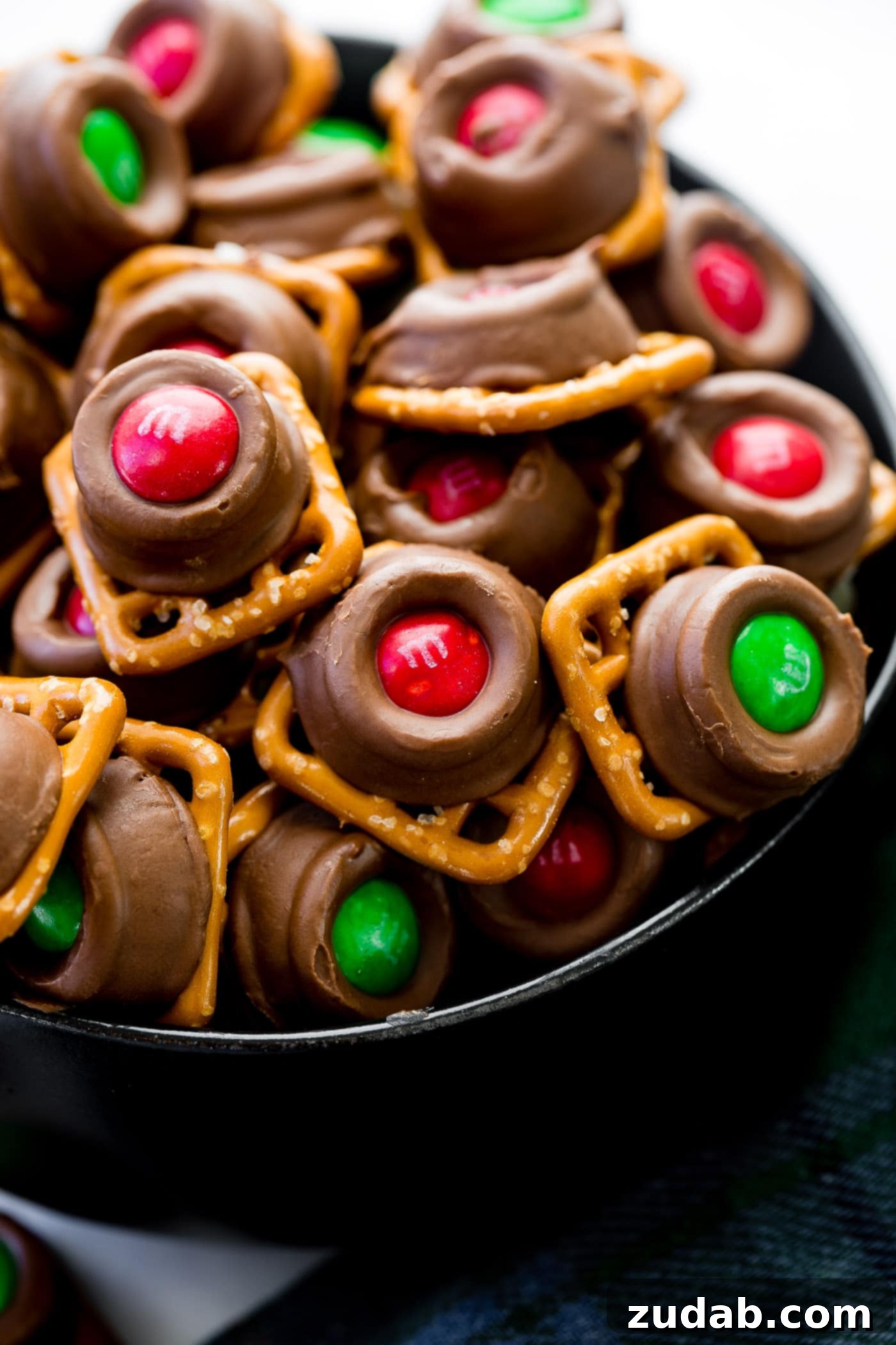 Rolo Pretzels with M&Ms A stack of square pretzels topped with gooey Rolos—milk chocolates filled with caramel—and finished with festive Christmas M&Ms. The Rolo Pretzel Bites with M&Ms are festive and the perfect holiday treat!