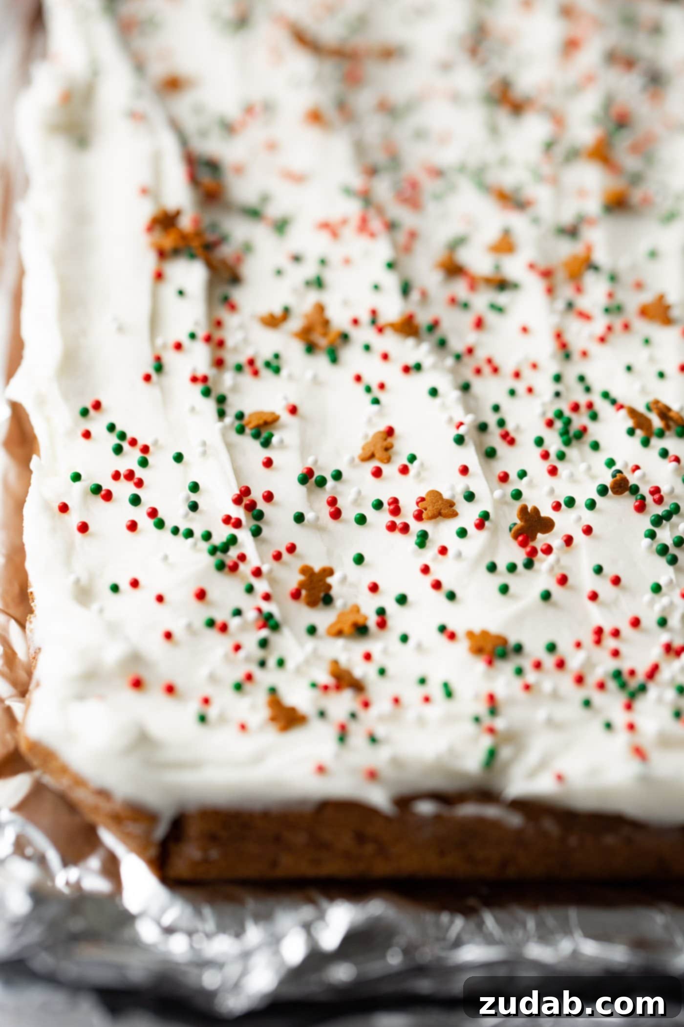 Gingerbread Bars with Cream Cheese Frosting A pan filled with freshly baked gingerbread bars, generously frosted with cream cheese frosting, awaiting its final cuts.