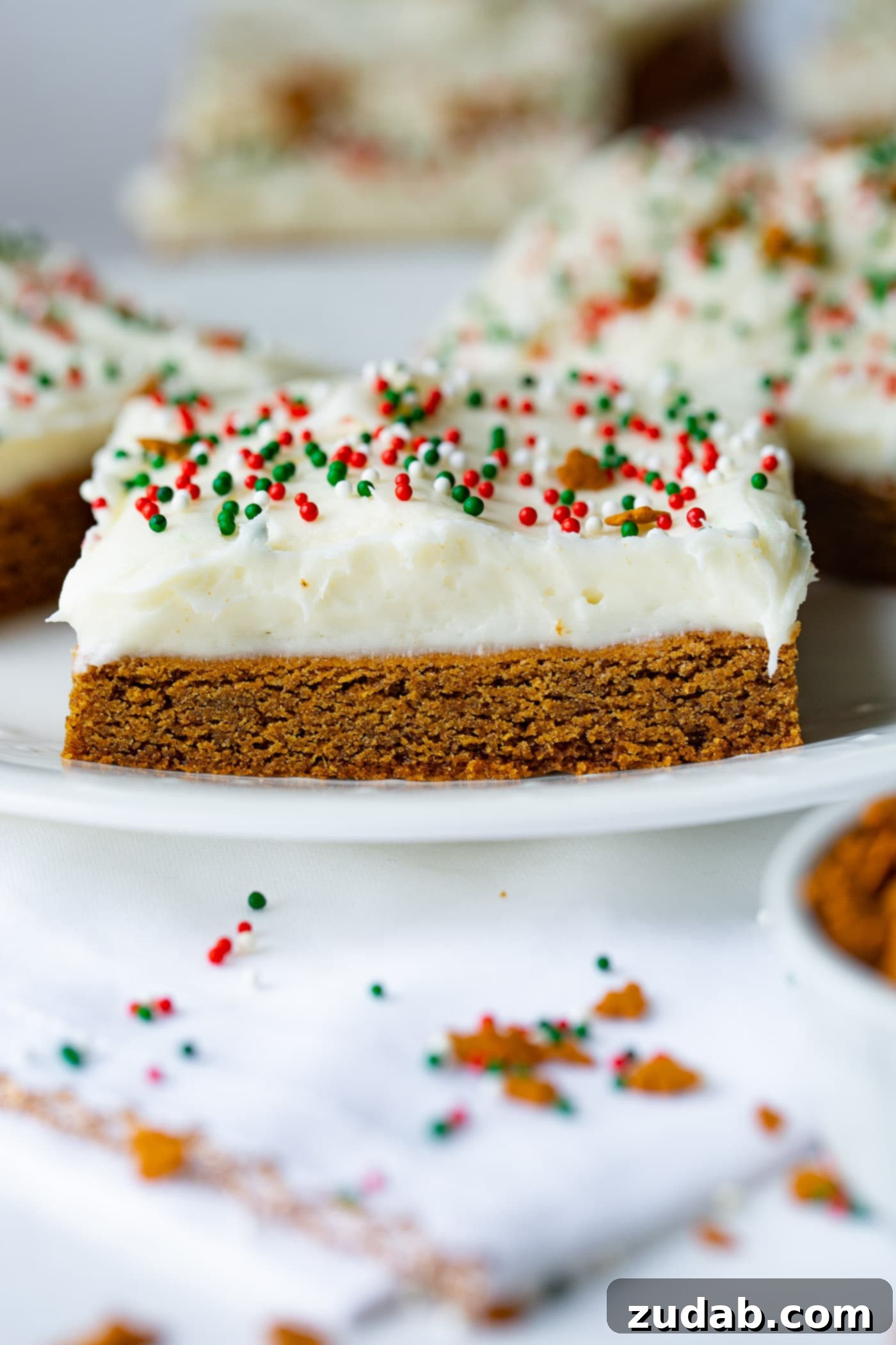 Gingerbread Bars with Cream Cheese Frosting A single, perfectly frosted gingerbread bar resting on a pristine white plate, a testament to its simple elegance.