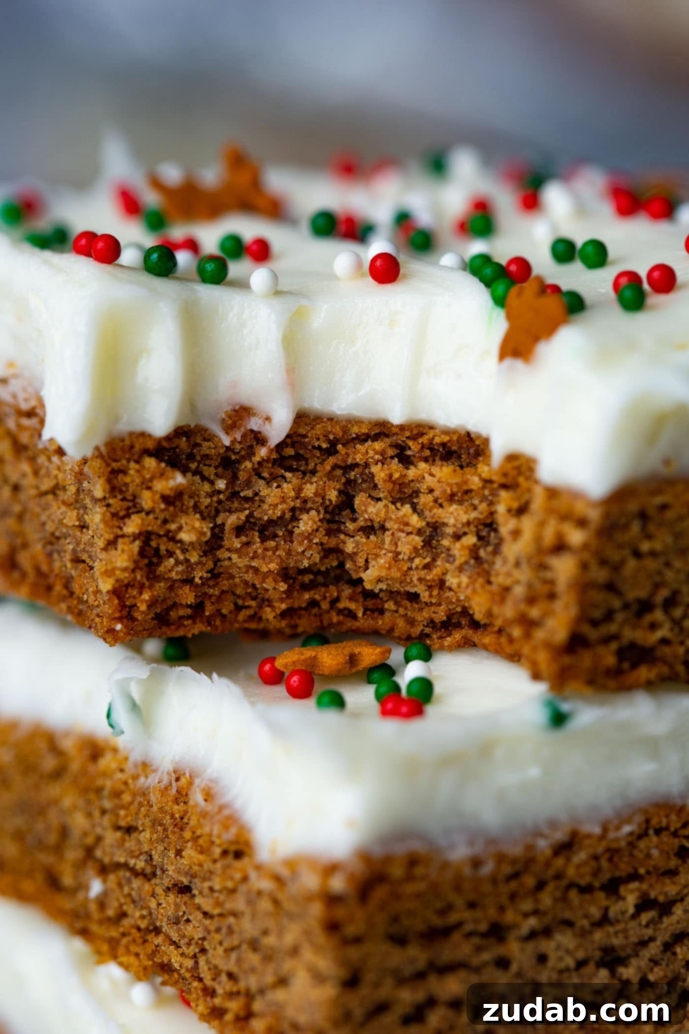 Gingerbread Bars with Cream Cheese Frosting Another enticing photo of gingerbread bars, frosted with luxurious cream cheese and stacked artfully, with one bar showing a delicious bite mark.