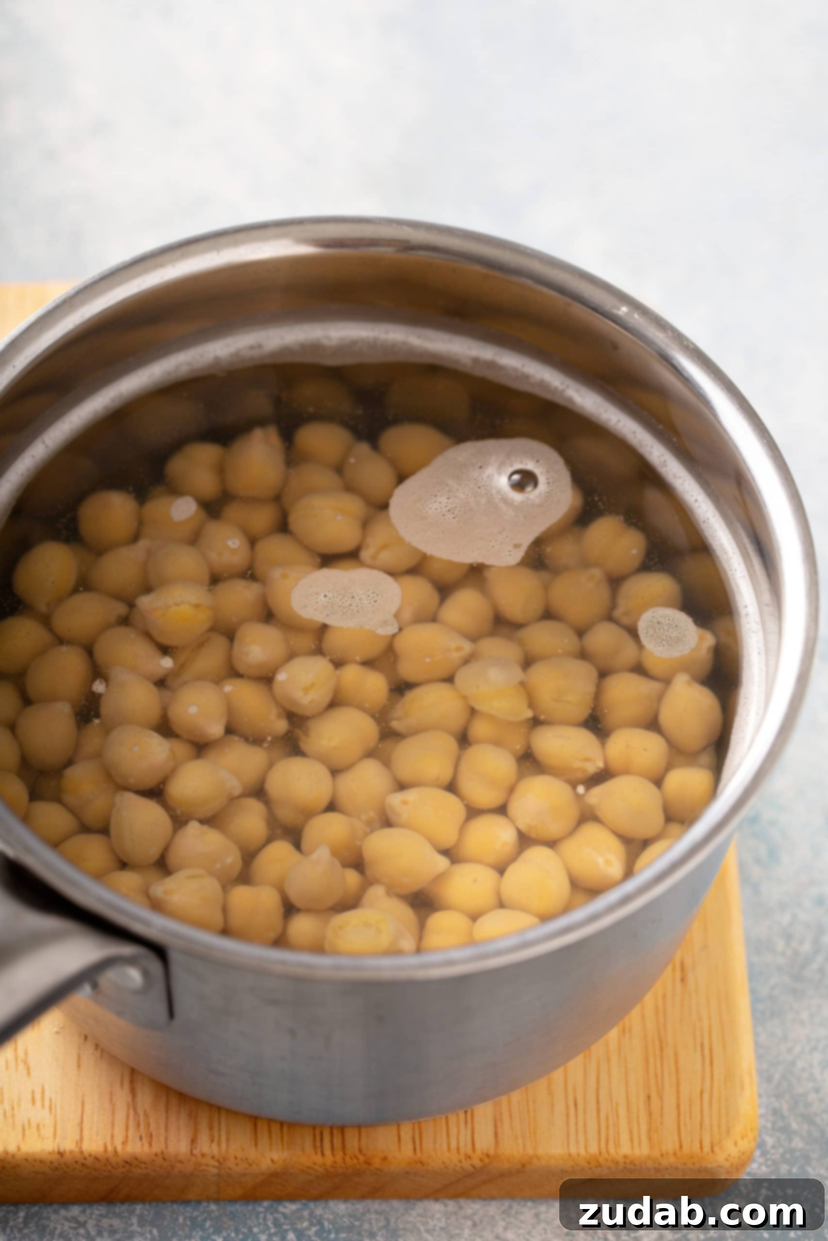 Chickpeas Boiling for Hummus A saucepan filled with chickpeas and water, ready to be boiled with a touch of baking soda for optimal softness.