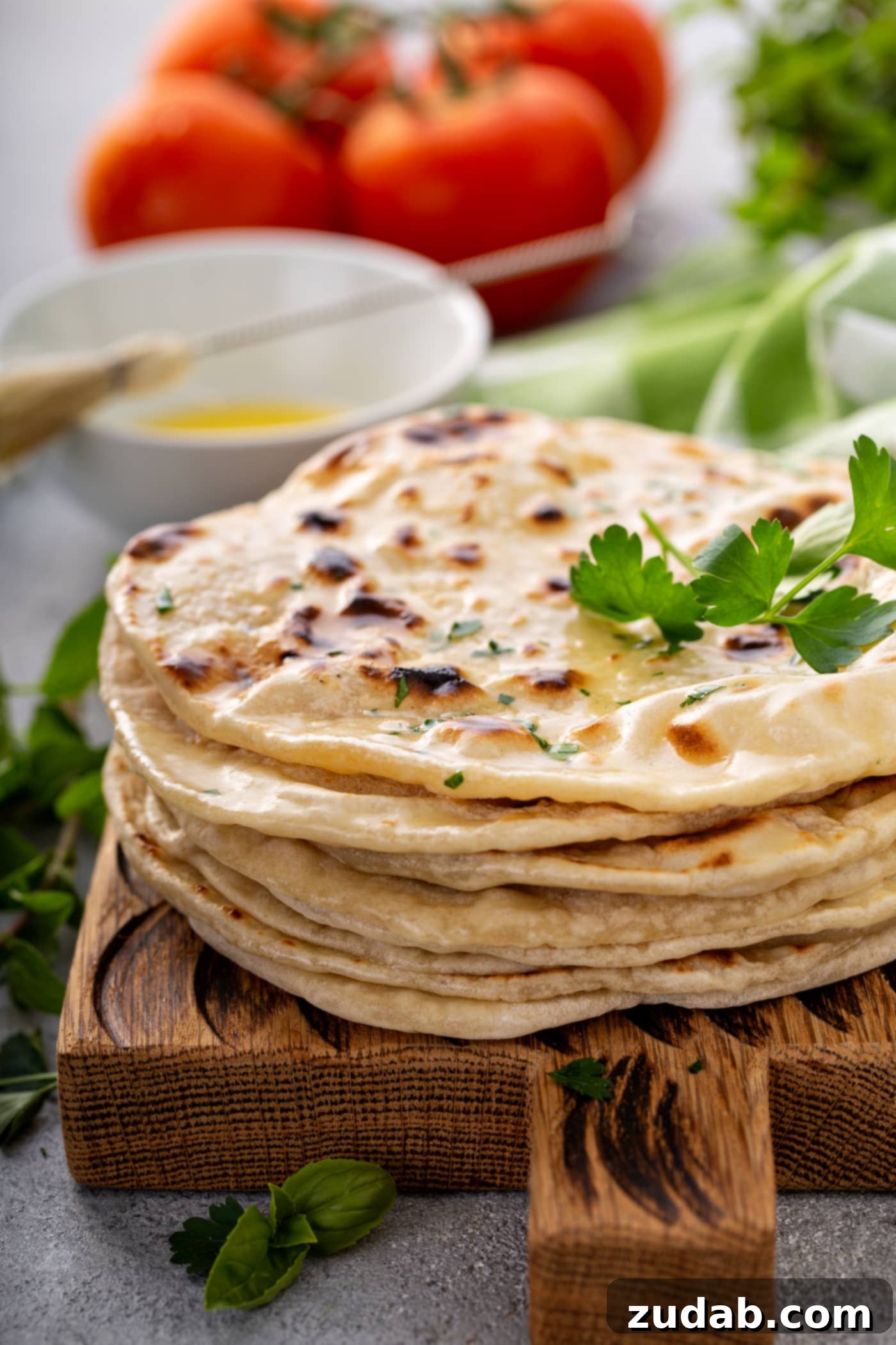 Unleavened Bread A photo of a stack of cooked discs of bread topped with chopped fresh parsley and a sprig of fresh parsley.