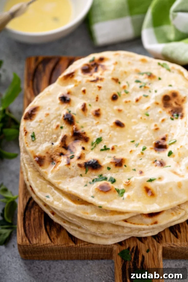 Whip Up Three Ingredient Unleavened Bread 5 A photo of a stack of cooked discs of unleavened bread topped with chopped fresh herbs.