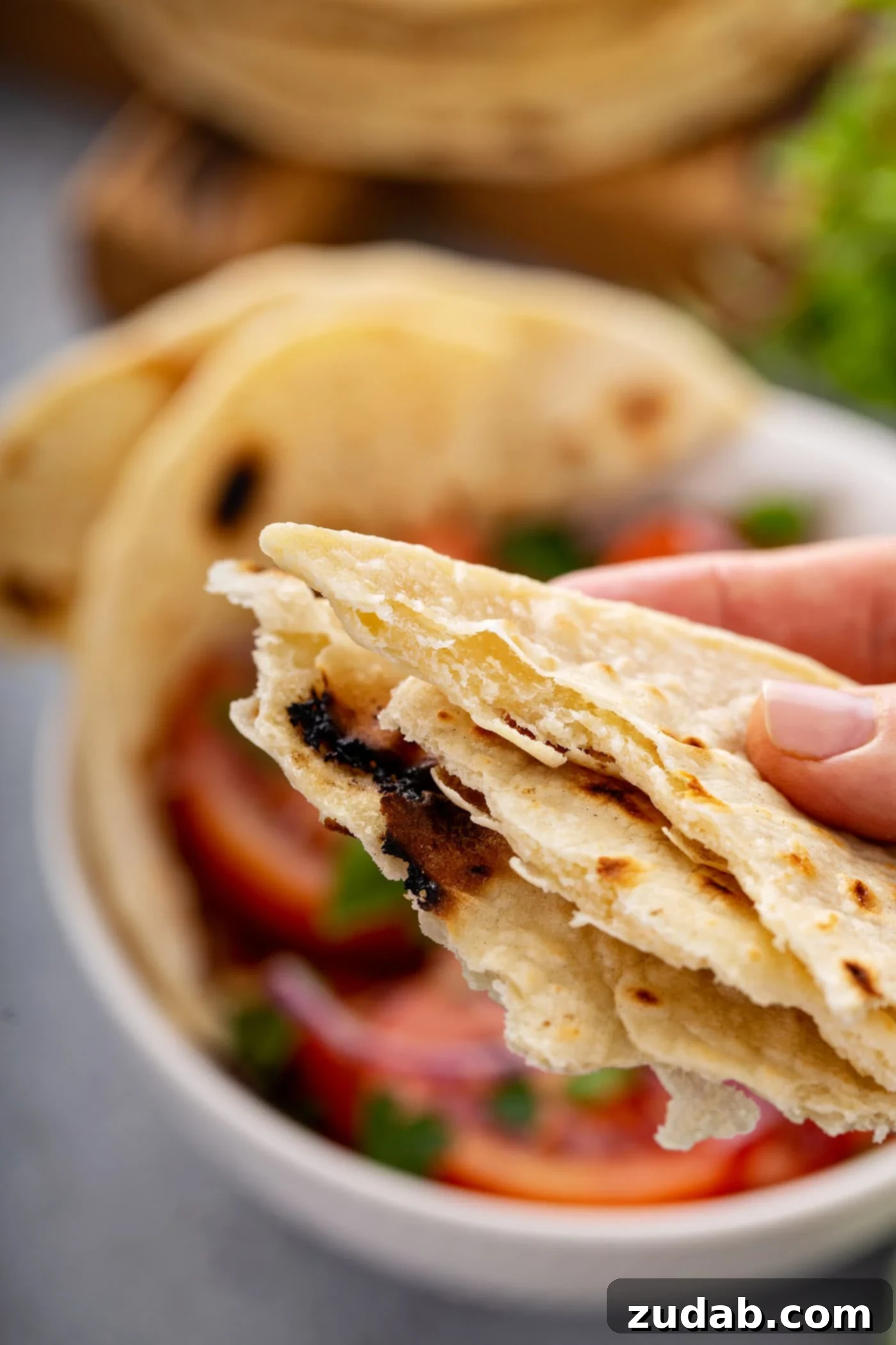 Unleavened Bread A photo of someone holding portions of torn unleavened bread.