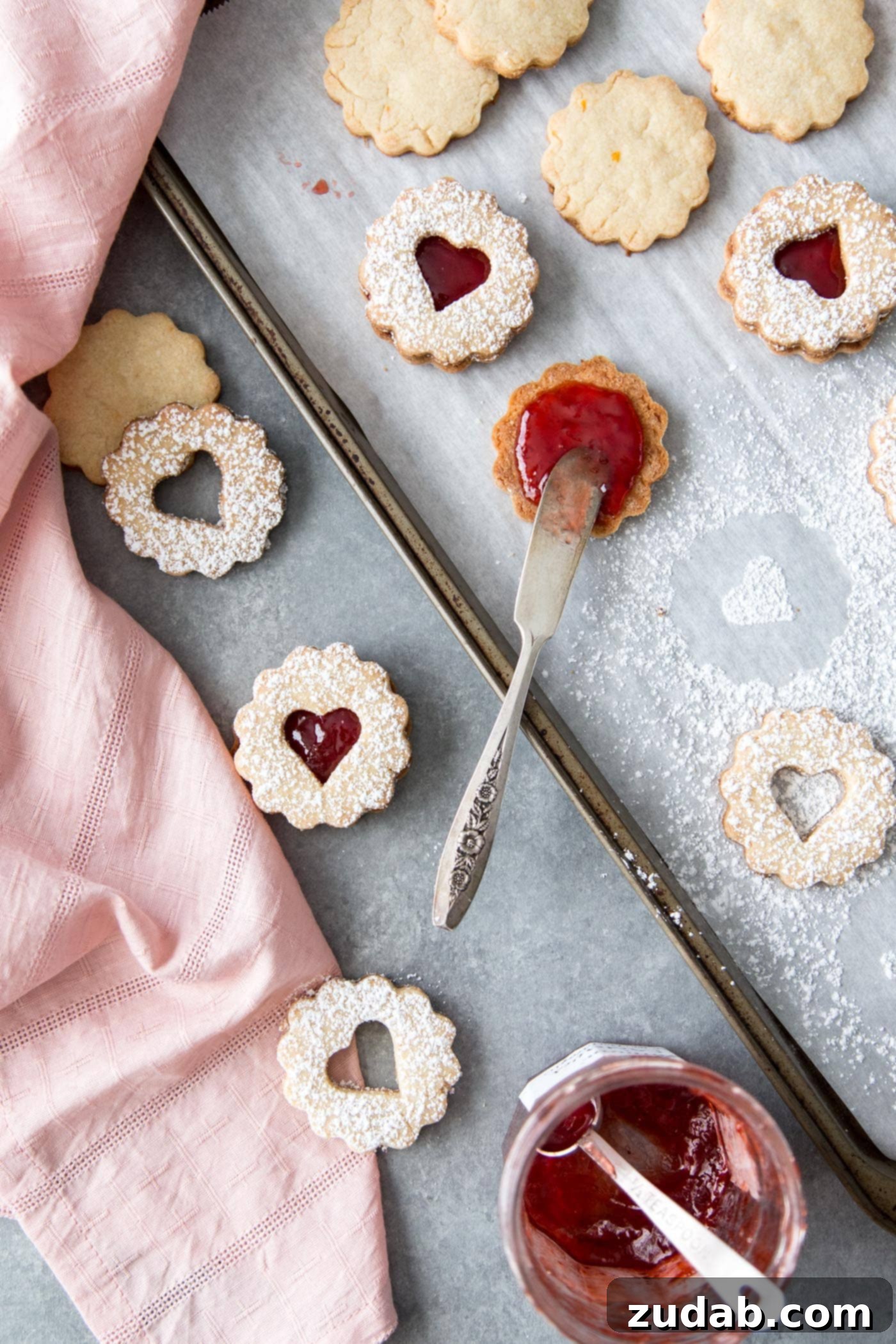 Classic Linzer Cookies 4 Close-up of strawberry jam being added to the bottom half of a Linzer cookie