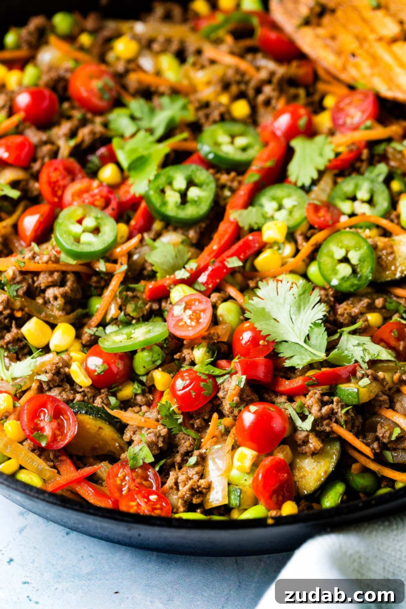 Fiesta Skillet Stir-Fry 5 A close-up shot of the savory taco skillet, showcasing ground beef, bright corn, tender zucchini, sliced jalapenos, and carrots all mixed together in a rich sauce.