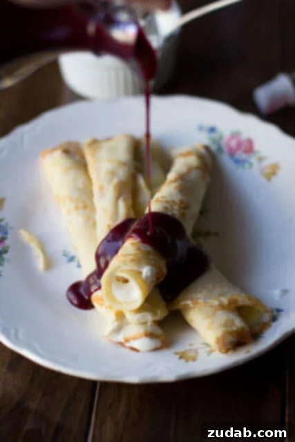 Marionberry Strawberry Syrup served over the most delicious cream filled crepes. #Breakfast at our house is amazing. ohsweetbasil.com Marionberry Strawberry Syrup served over delicious cream-filled crepes, perfect for a family breakfast or special occasion.