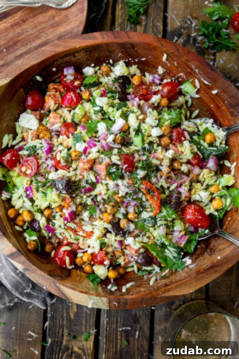 Zesty Mediterranean Orzo Salad 6 A large bowl of Greek orzo pasta salad, freshly tossed with homemade dressing and a sprinkle of grated Parmesan cheese, ready to be served.