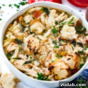 Hearty Instant Pot Italian Chicken Soup 4 A close-up of a bowl of Instant Pot Italian Chicken Soup, garnished with a sprinkle of fresh Parmesan and a sprig of parsley.