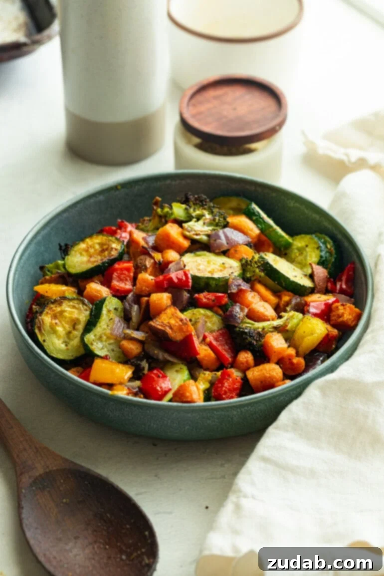 Perfectly Roasted Garden Medley 2 Crispy-tender vegetables piled in a blue bowl, showcasing the mix of orange, green, red, and yellow in every bite.