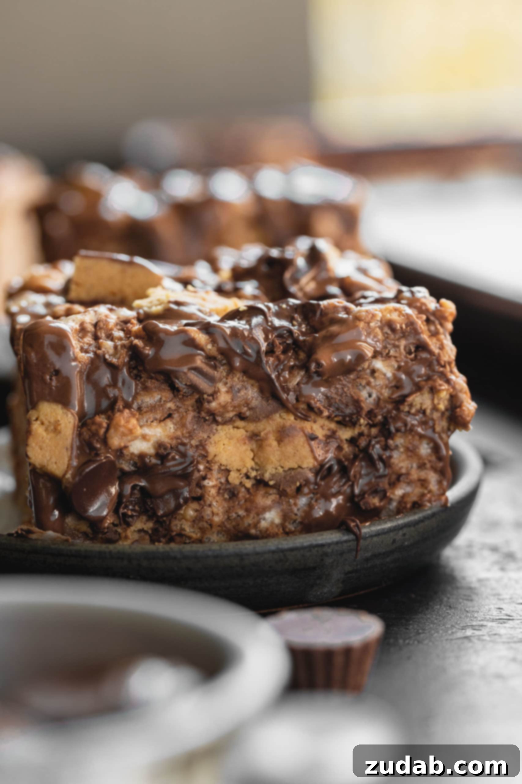Reese's Rice Krispies Treats A photo of the cross-section of a peanut butter rice krispies treat that is loaded with chunks of Reese's Peanut Butter Cups and melty chocolate chips.