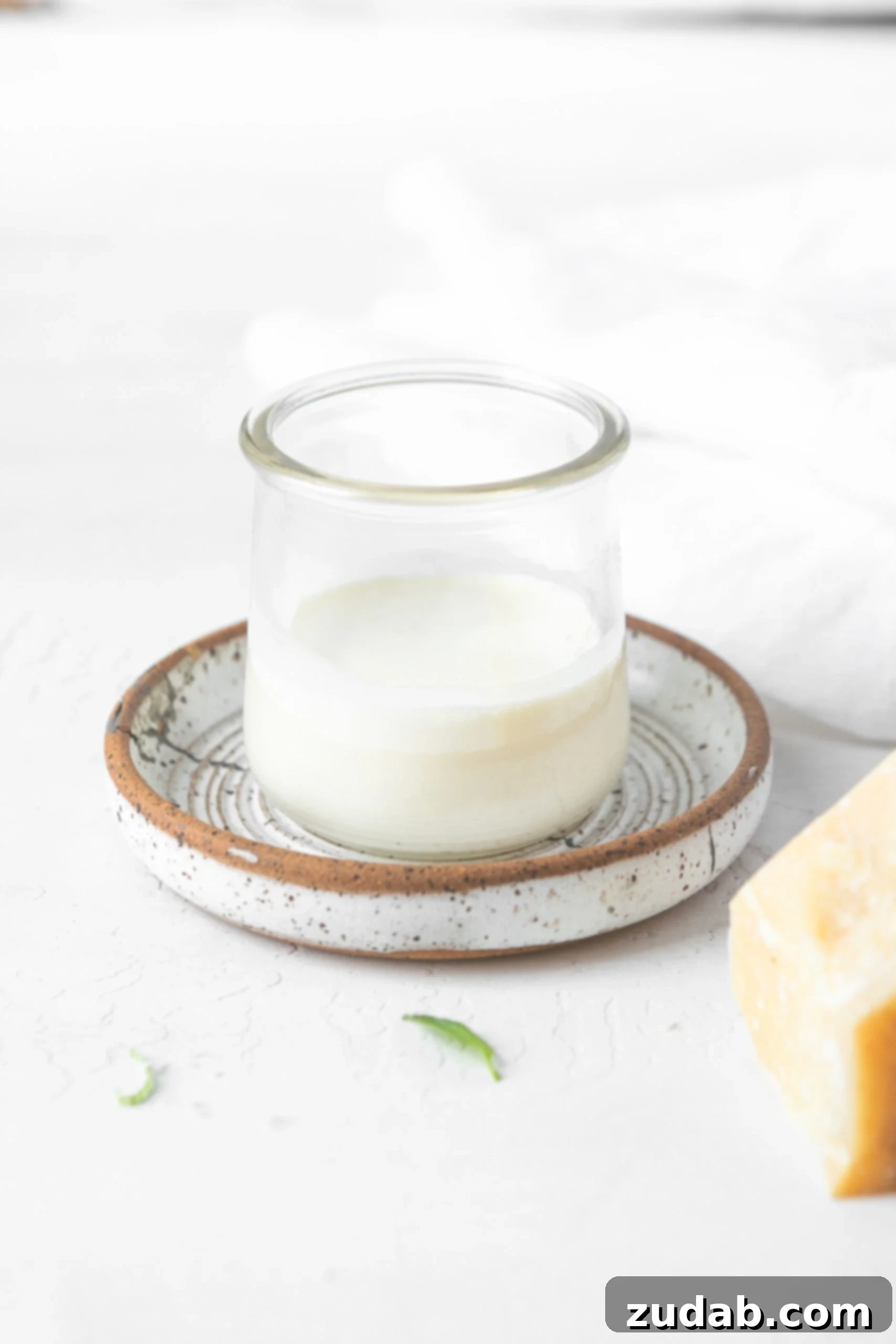 Heavy Cream and Parmesan Mixture A glass of rich heavy cream blended with grated Parmesan cheese, poised to create a decadent sauce for the gnocchi.