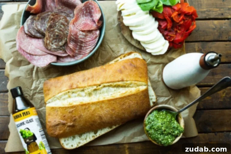 Italian Panini 2 A photo of all the ingredients for Italian pressed sandwiches including ciabatta bread, pesto, sliced Italian meats, fresh mozzarella slices, roasted red peppers, and fresh spinach