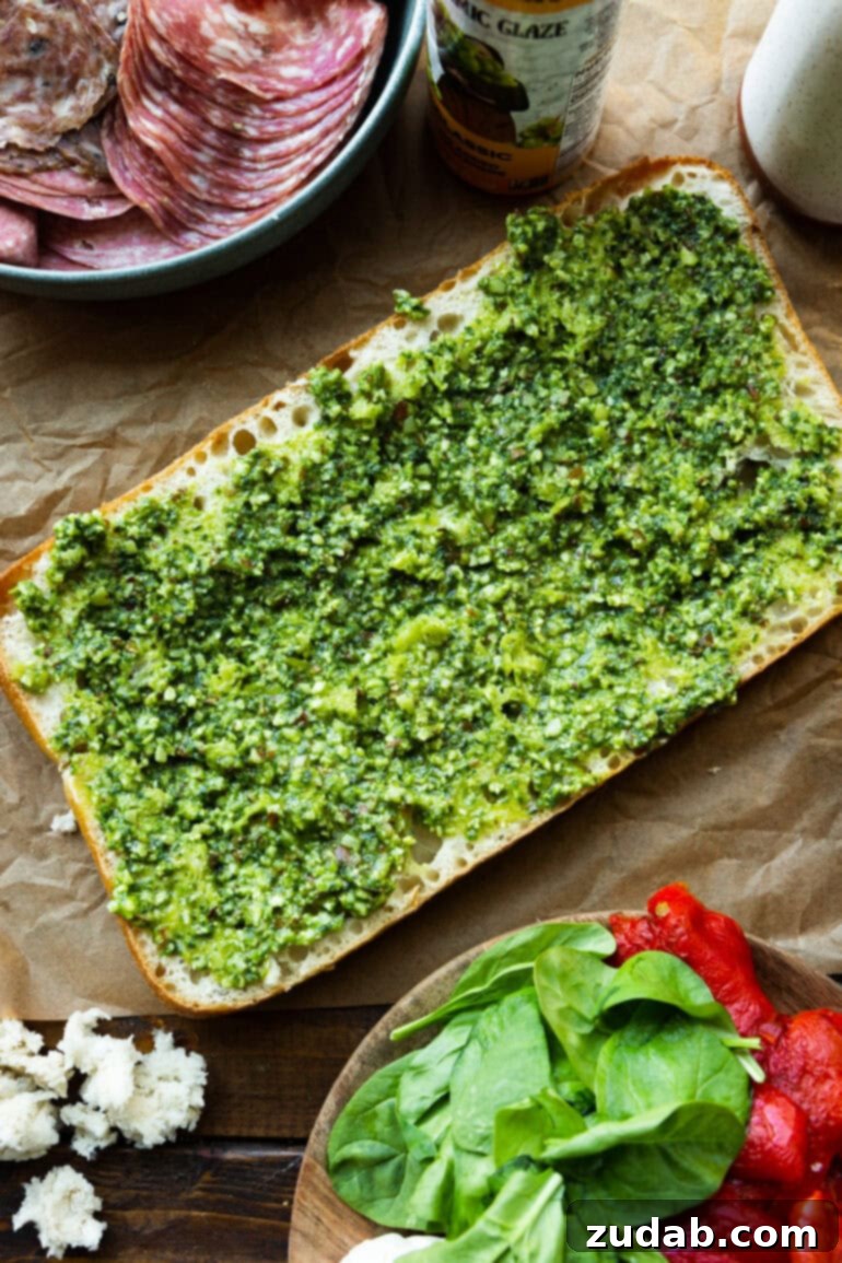 Italian Panini 4 Step-by-step image of spreading pesto on Italian bread.