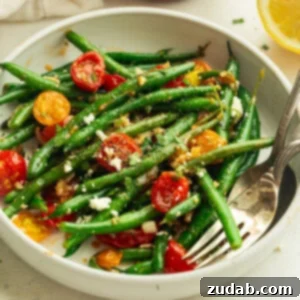 Top view of Sautéed Green Beans and Cherry Tomatoes in a white bowl.