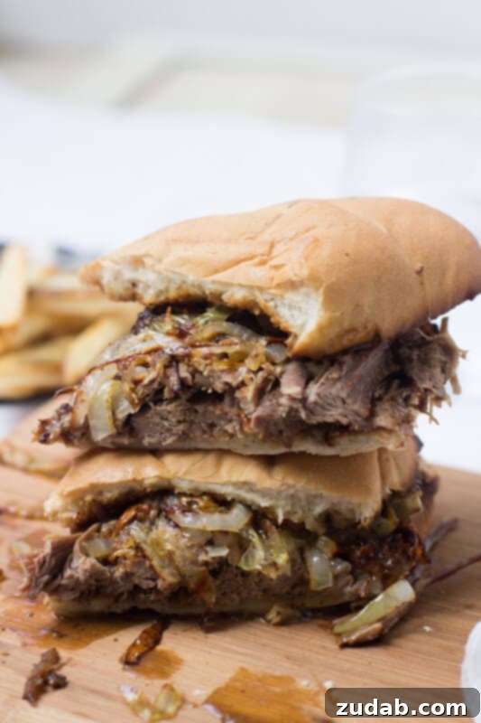This pot roast sandwich is going to have husbands everywhere proposing all over again. Mark. My. Words. It's just that good. Simple Pot Roast sandwich cut in half on a wooden board.