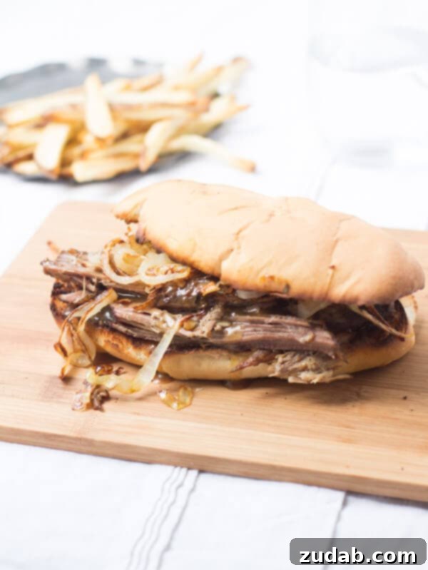 This pot roast sandwich is going to have husbands everywhere proposing all over again. Mark. My. Words. It's just that good. Delicious Pot Roast sandwich recipe on a wooden board.