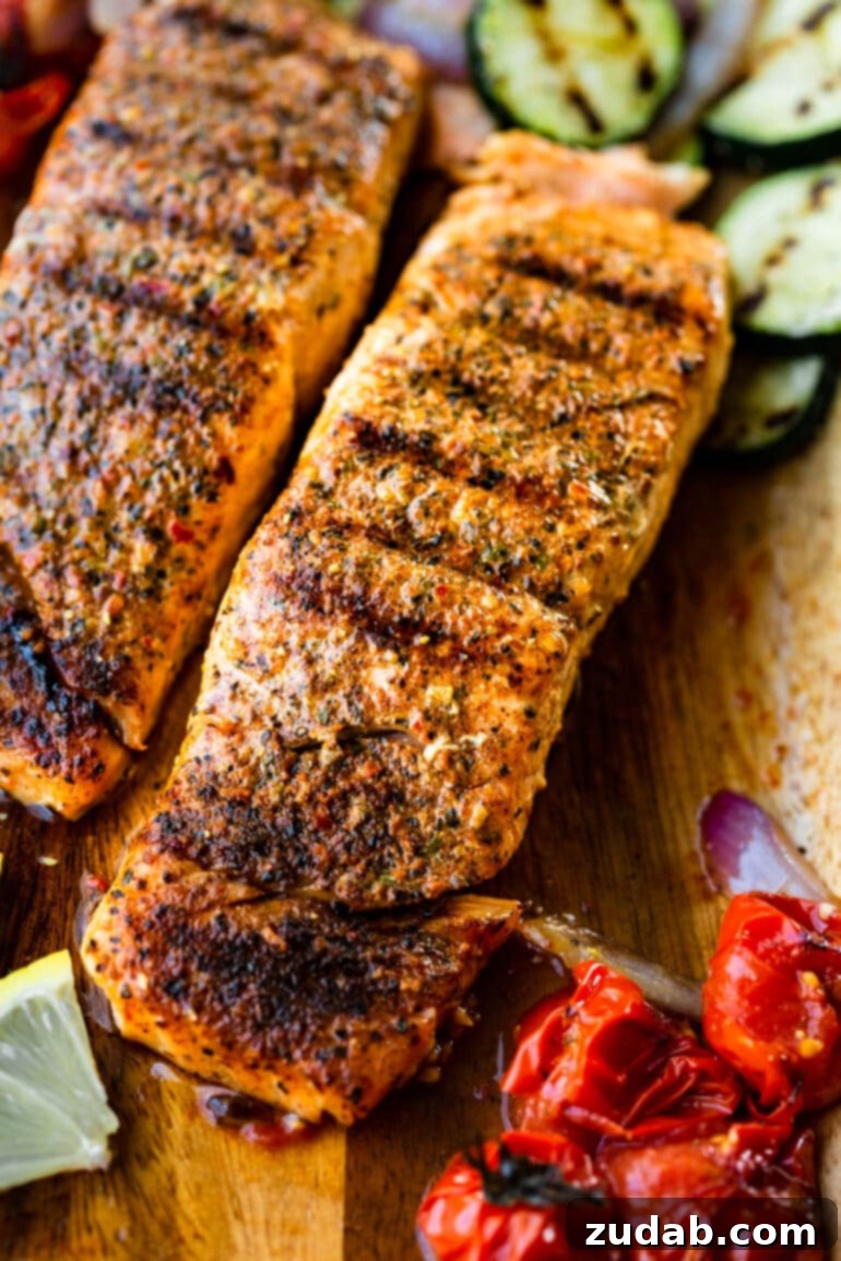 The Ultimate Guide to Perfectly Grilled Salmon 4 Two perfectly grilled salmon fillets, showcasing beautiful grill marks and a crispy skin, arranged on a rustic wooden plank with a side of colorful grilled vegetables. This image epitomizes summer grilling and healthy eating.