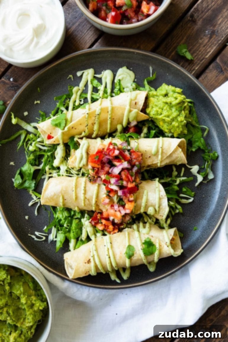 Weekly Meal Plan October 30 to November 5 5 A dark plate showcasing golden-baked chicken taquitos, elegantly drizzled with creamy avocado crema, served over crisp lettuce and topped with vibrant pico de gallo.