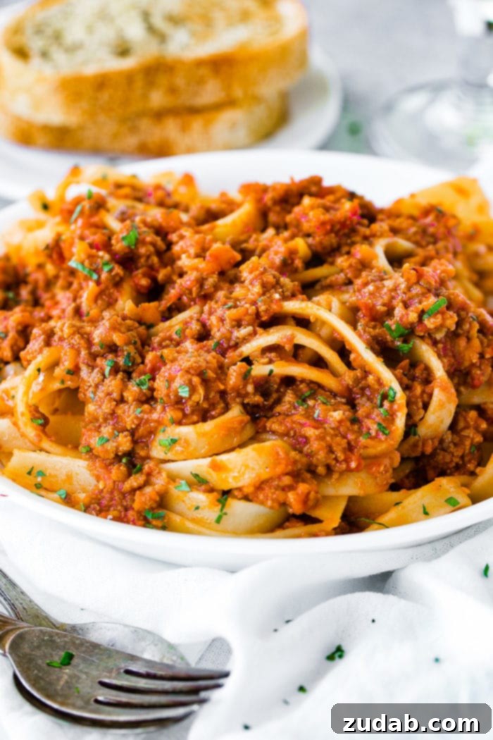 Weekly Meal Plan October 30 to November 5 8 A pristine white pasta dish generously laden with fettuccine pasta, expertly coated in a rich and authentic Italian Bolognese sauce, inviting a delightful culinary experience.