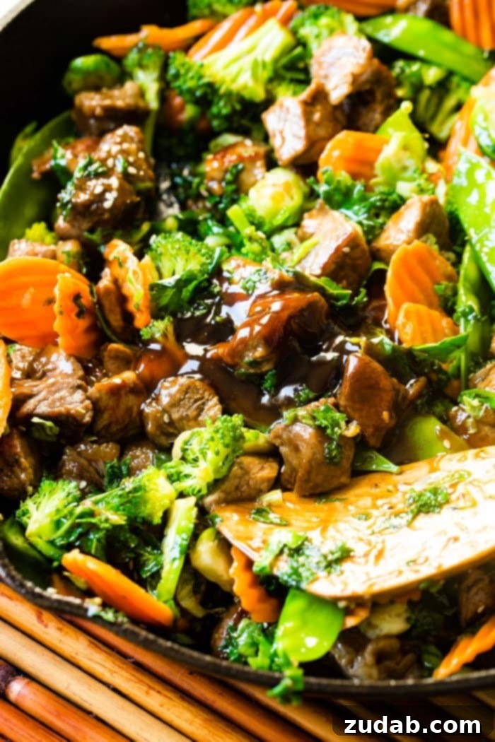 A vibrant photo of a sesame steak stir fry, generously loaded with a colorful array of fresh vegetables and beautifully topped with white sesame seeds.