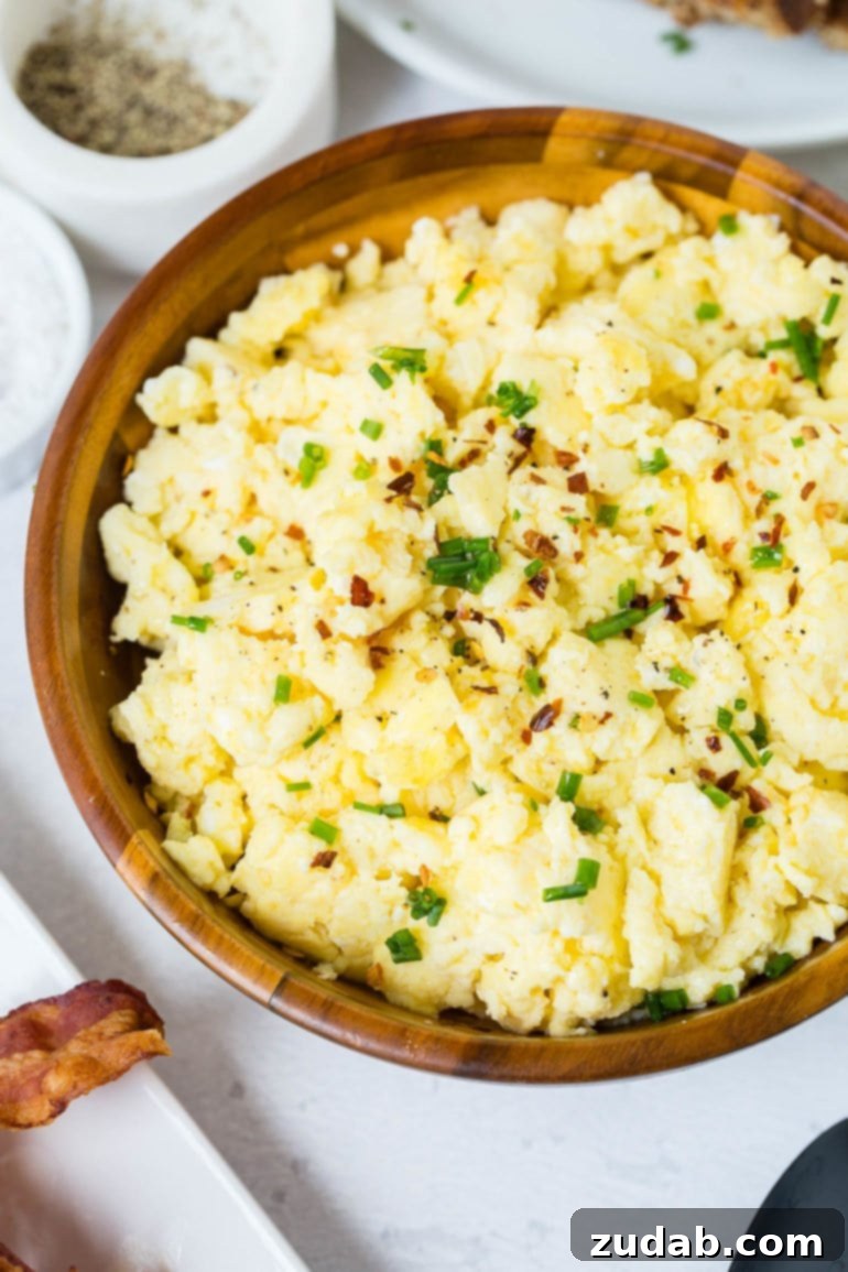 Our Weekly Meal Plan: April 29 - May 5 8 A charming bowl of exquisitely fluffy scrambled eggs, delicately garnished with vibrant sliced green onion, promising a delightful and savory breakfast experience.