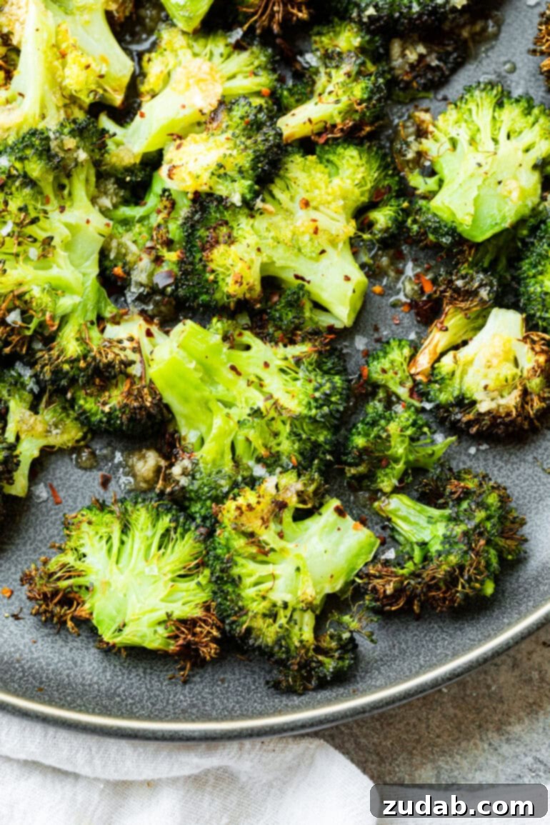 Golden Crispy Air Fryer Smashed Broccoli 2 A vibrant photo of a serving plate generously piled with golden-brown, crispy smashed broccoli florets, showcasing their perfect texture and inviting appeal. Ideal for a healthy, quick air fryer recipe.