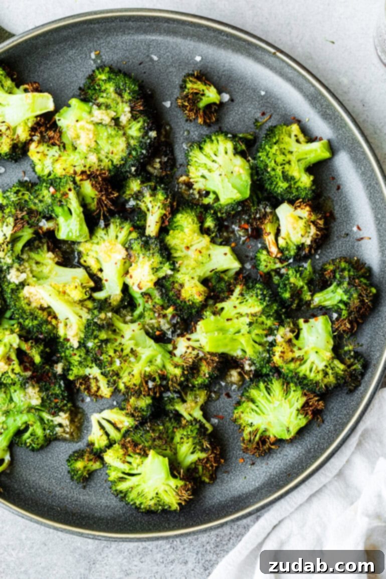 Golden Crispy Air Fryer Smashed Broccoli 6 An overhead view of a plate overflowing with vibrant, crispy smashed broccoli florets. This captivating image showcases the perfect texture for a healthy, easy air fryer recipe that promises flavor in every bite.