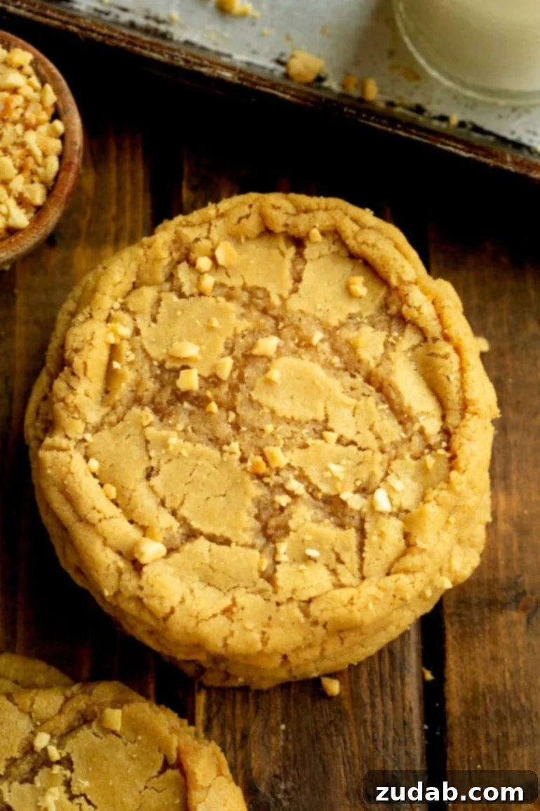 Bakery-Style Peanut Butter Dream Cookies 6 Overhead view of a large chewy peanut butter cookie on a wooden table.