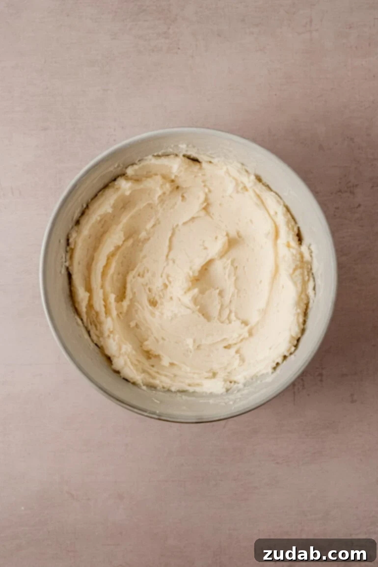 From Box to Bliss: Elevating Simple Chocolate Cake 15 Vanilla buttercream frosting being whipped in a mixer.