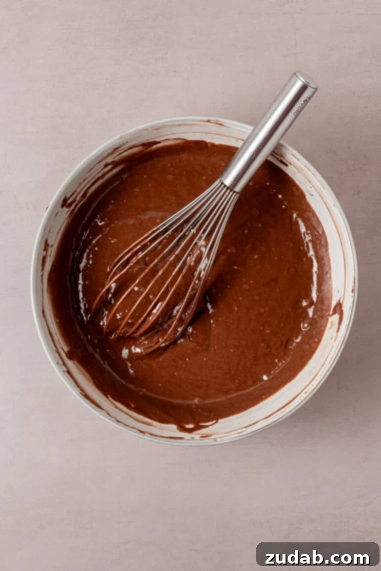 From Box to Bliss: Elevating Simple Chocolate Cake 10 Cake batter being poured into cake pans.
