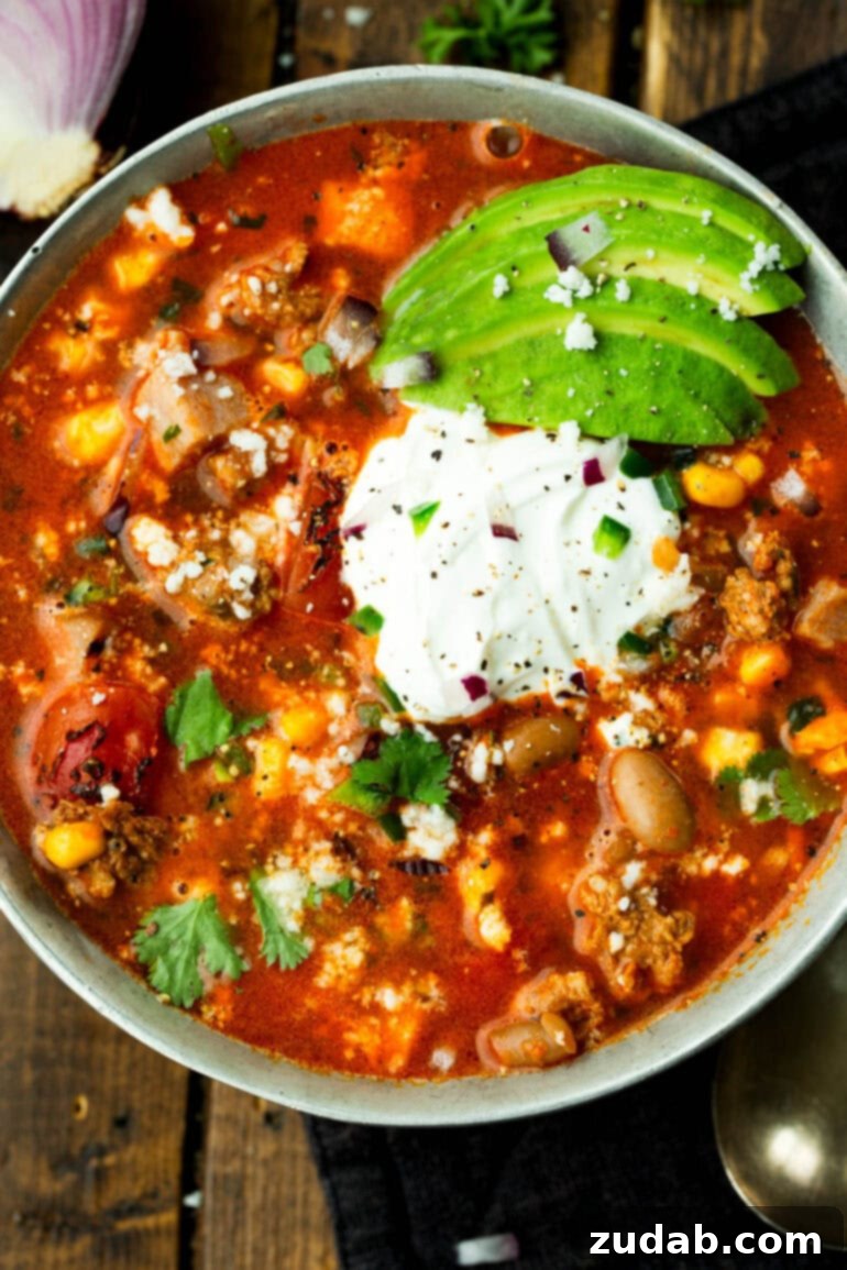 Cowboy Pinto Bean Soup Recipe 2 A bowl of Charro Bean Soup topped with sour cream and sliced avocados