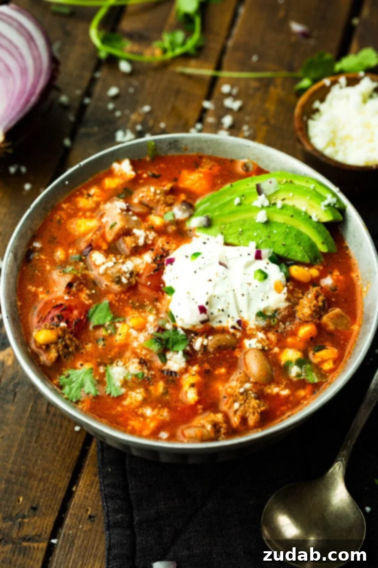 Cowboy Pinto Bean Soup Recipe 3 A bowl of hearty charro bean soup topped with sour cream, sliced avocados, and chopped cilantro