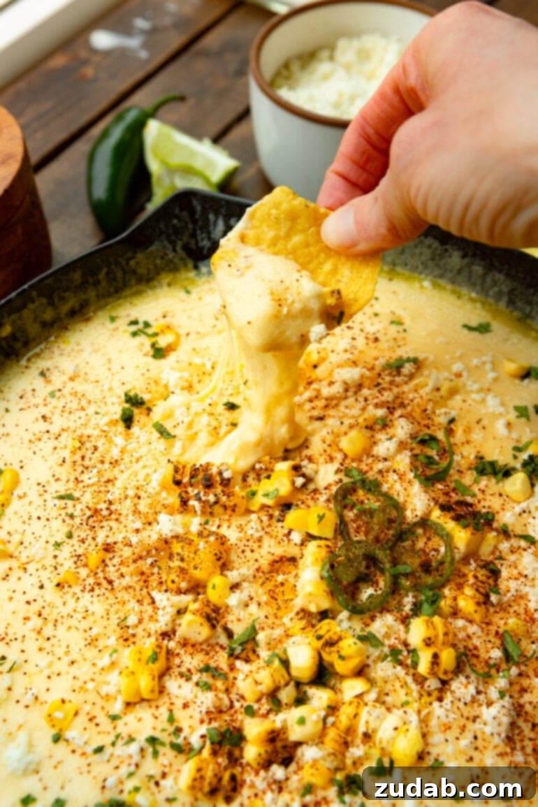 Elote-Inspired Queso Dip 2 Skillet filled with creamy Mexican elote queso dip topped with roasted corn, cilantro, and cotija cheese.