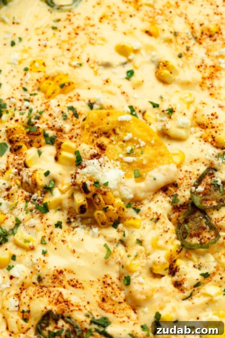 Elote-Inspired Queso Dip 6 Overhead shot of melted cheese dip mixed with sweet corn and served with tortilla chips
