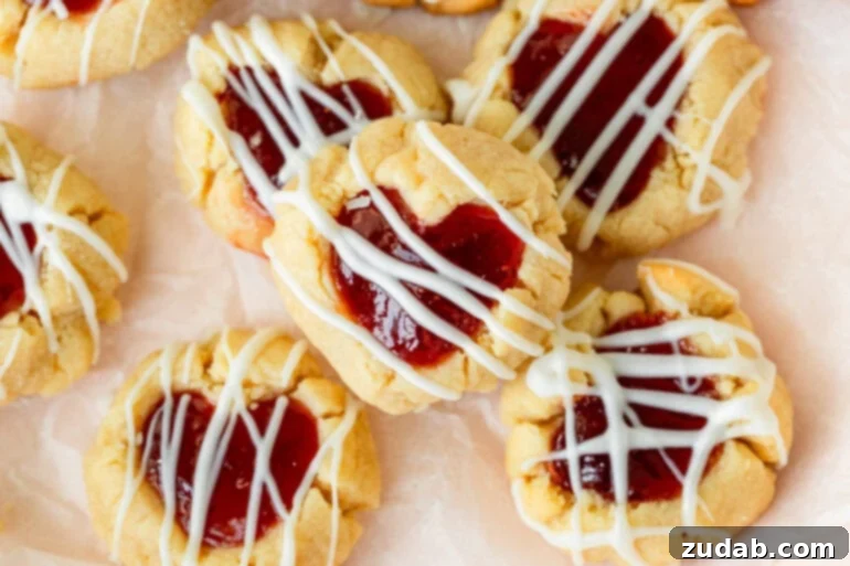 Valentine's Day Thumbprint Cookies: A Sweet Treat for Your Loved Ones 4 buttery thumbprint cookies with strawberry and raspberry jam in heart-shaped centers.