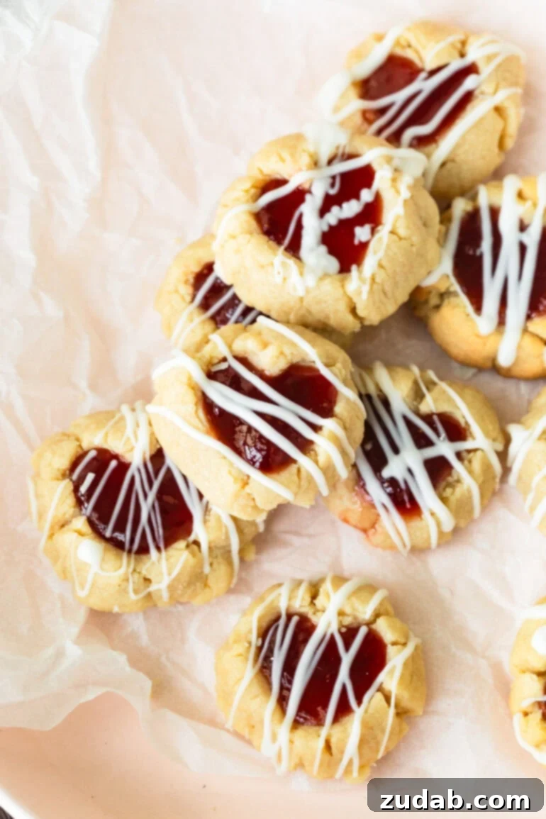 Valentine's Day Thumbprint Cookies: A Sweet Treat for Your Loved Ones 5 several Valentine's thumbprint cookies filled with dark red jam and drizzled with melted white chocolate