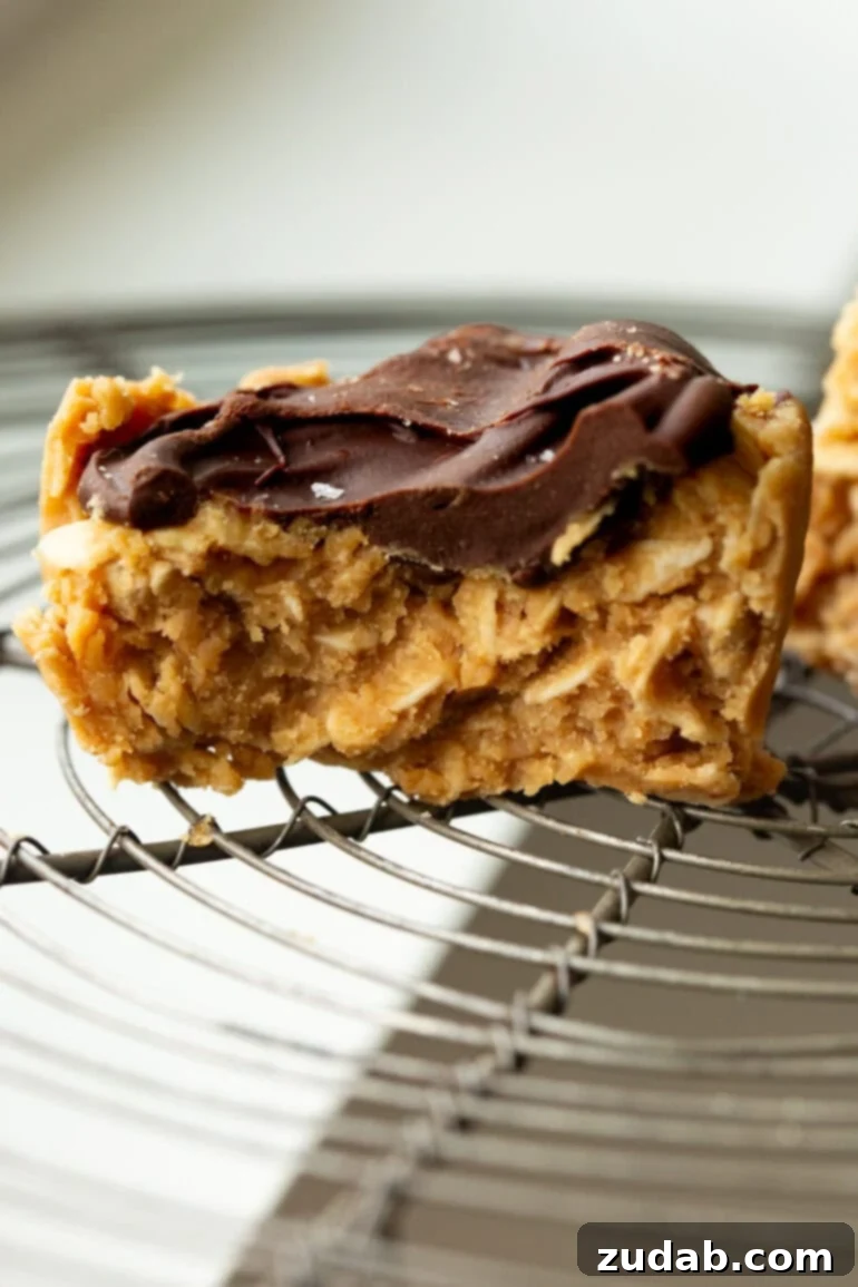 Chocolate Peanut Butter Oatmeal Cups 4 The cross-section of a peanut butter oat cup topped with chocolate sitting on a wire cooling rack