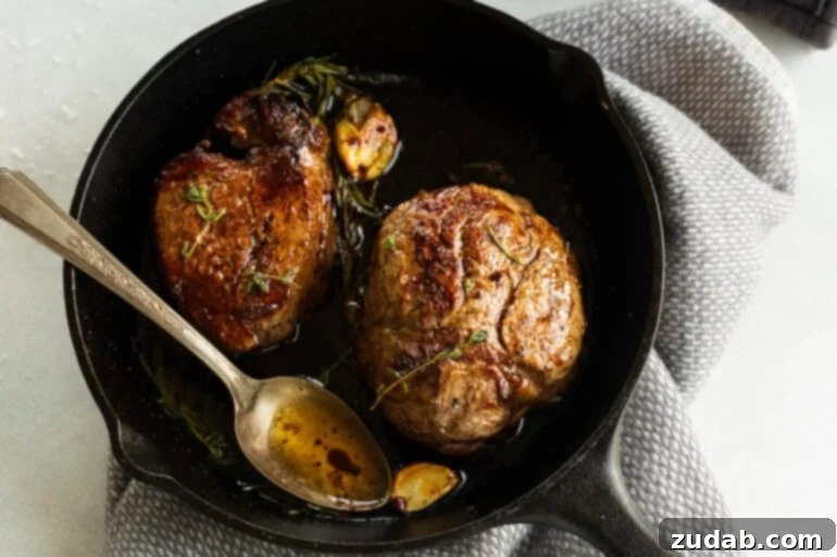 The Ultimate Guide to Filet Mignon: Restaurant-Quality Results at Home 6 Pan-seared filet mignons in a cast iron skillet with herbs and butter