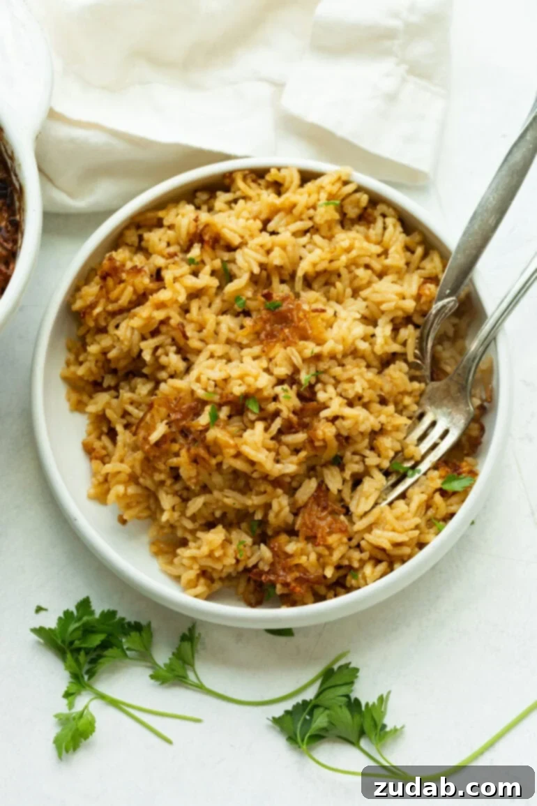 Golden Onion Butter Rice 4 Buttery rice cooked to perfection in the oven and dished up in a ceramic bowl.