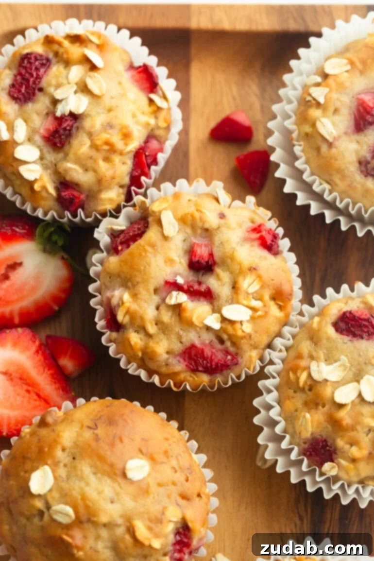 Super Soft Strawberry Oat Muffins Infused with Greek Yogurt 2 An overhead view of freshly baked, individual healthy strawberry oat muffins with a dusting of oats on top, ready to be enjoyed.