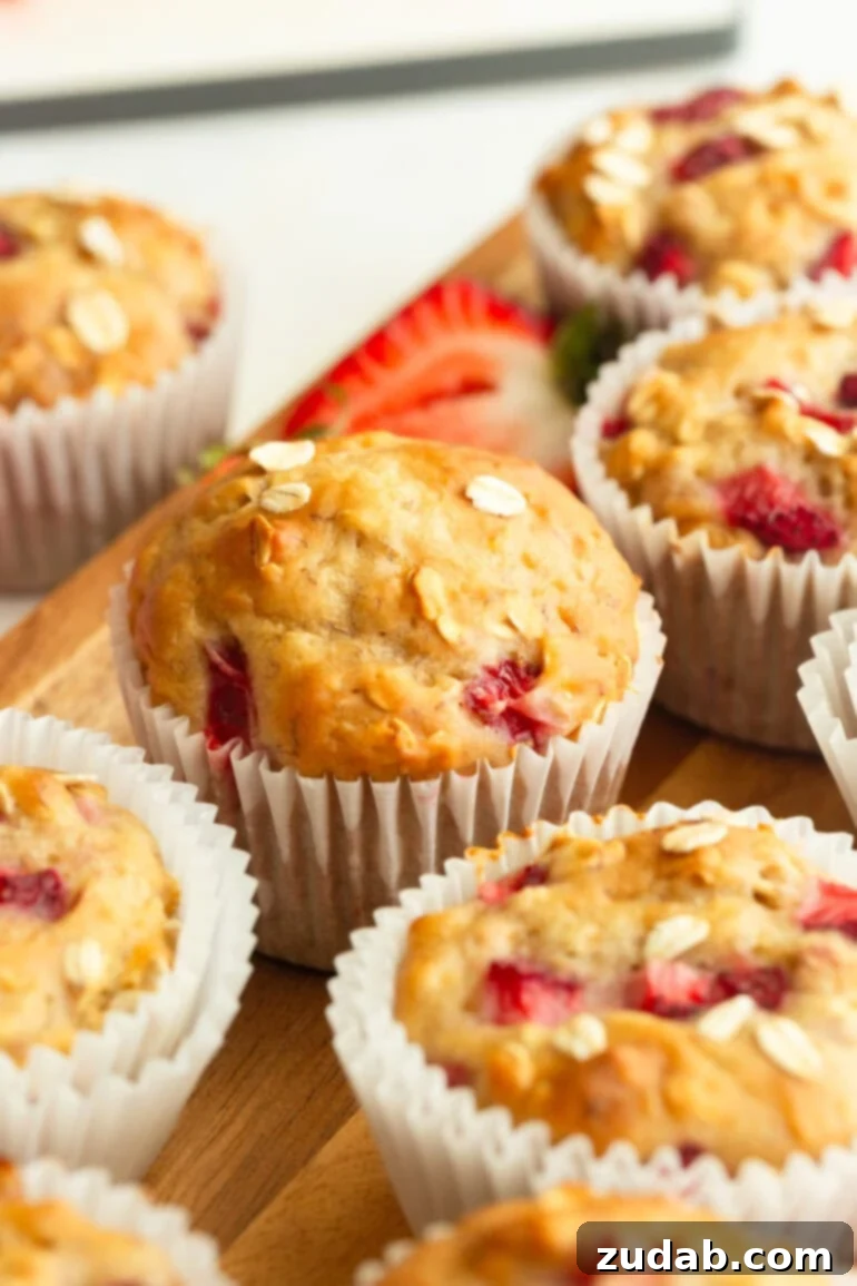 Super Soft Strawberry Oat Muffins Infused with Greek Yogurt 3 A close-up shot revealing the tender crumb and juicy strawberry pieces within a healthy strawberry oat muffin, highlighting its fluffy texture.
