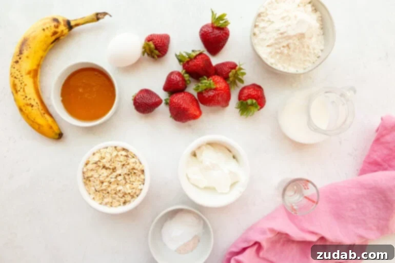 Super Soft Strawberry Oat Muffins Infused with Greek Yogurt 4 A bowl filled with the fresh ingredients for healthy berry breakfast cake, including diced strawberries, oats, and Greek yogurt, arranged on a rustic wooden surface.