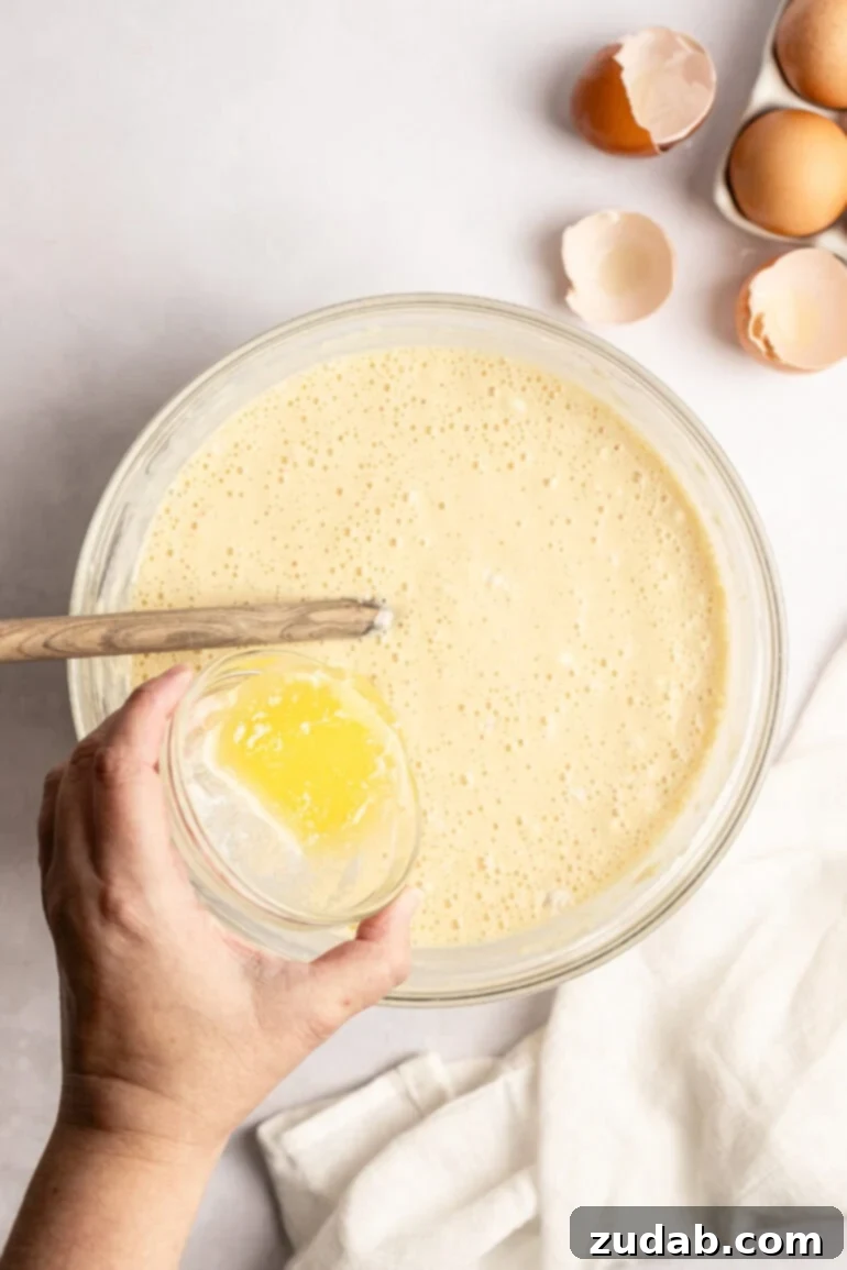 Step-by-step image of pouring batter onto a prepared baking sheet.