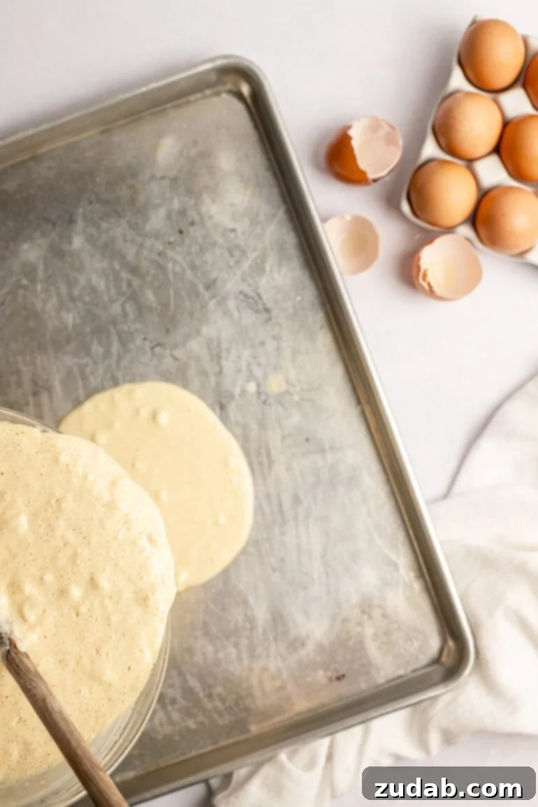 Step-by-step image of sprinkling strawberry slices over the pancake batter.